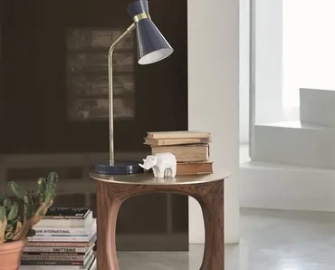 Tavolino di design con supporto centrale in massello di noce canaletta e piano e base in metallo finitura ottone spazzolato Tenco di Porada