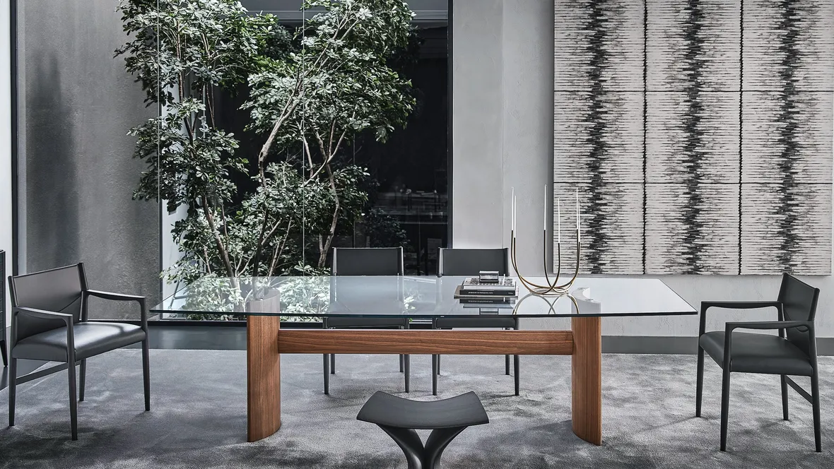 Tavolo con top in cristallo e due basi a mezzaluna in noce canaletta unite da una trave centrale in legno Beam di Porada