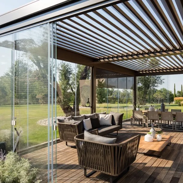 Pergola bioclimatica in alluminio con lame frangisole orientabili e pareti scorrevoli in vetro trasparente Opera di Pratic
