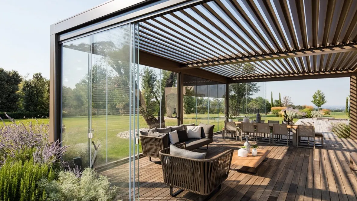 Pergola bioclimatica in alluminio con lame frangisole orientabili e pareti scorrevoli in vetro trasparente Opera di Pratic